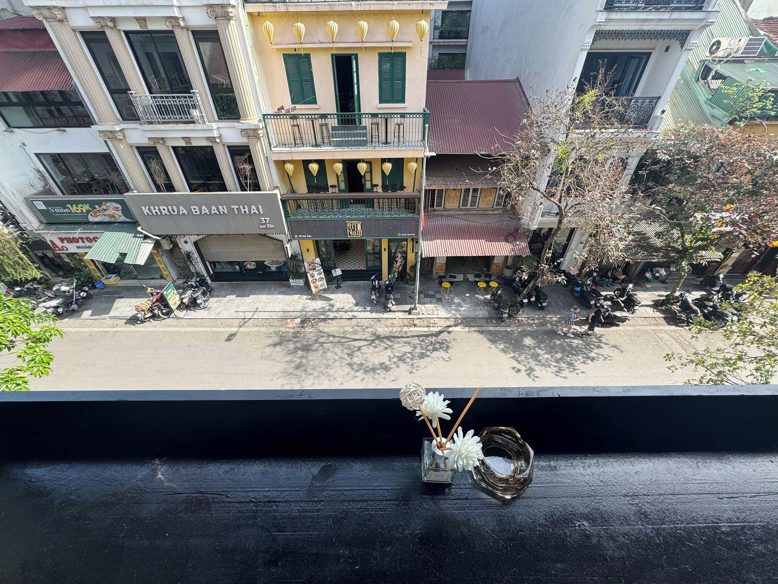 A street view with a restaurant named 'KARUA BAAN THAI' and a bar named 'Nai Nam' with outdoor seating.