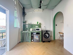 A compact kitchen with a washing machine, a microwave, and a sink. - Huge Balcony Home with Train Street View, Night Market, Max 6 (Hà Nội)