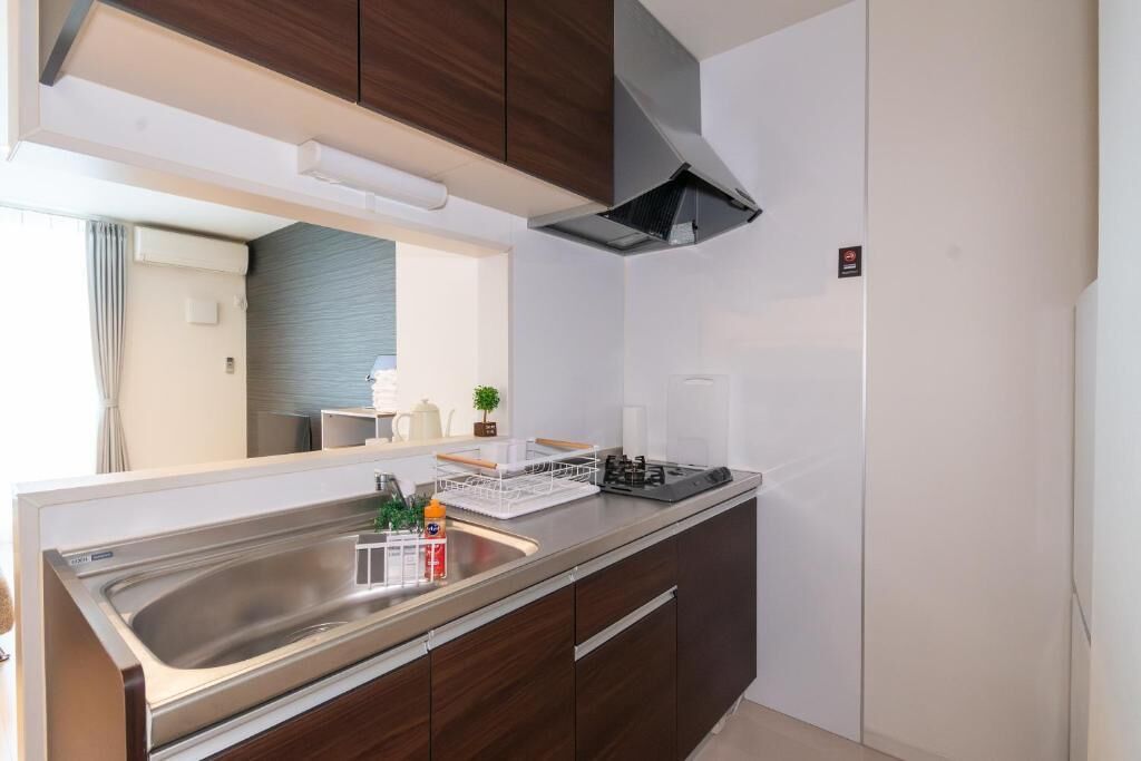 A modern kitchen with a stainless steel sink, a built-in stove, and wooden cabinets.