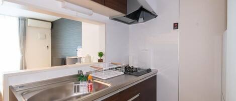 A modern kitchen with a stainless steel sink, a built-in stove, and wooden cabinets.