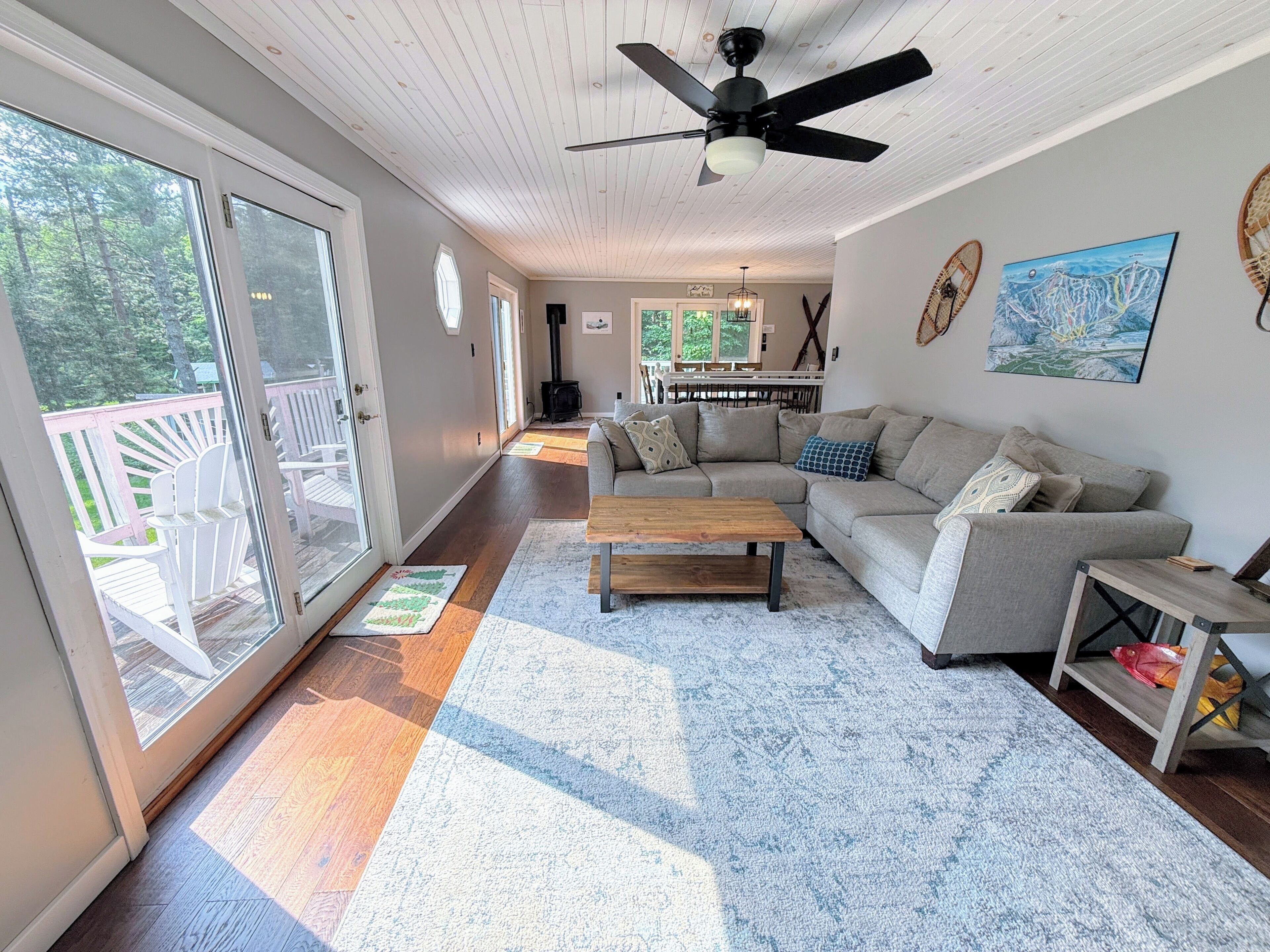 A spacious living room with a sofa, coffee table, and a ceiling fan.