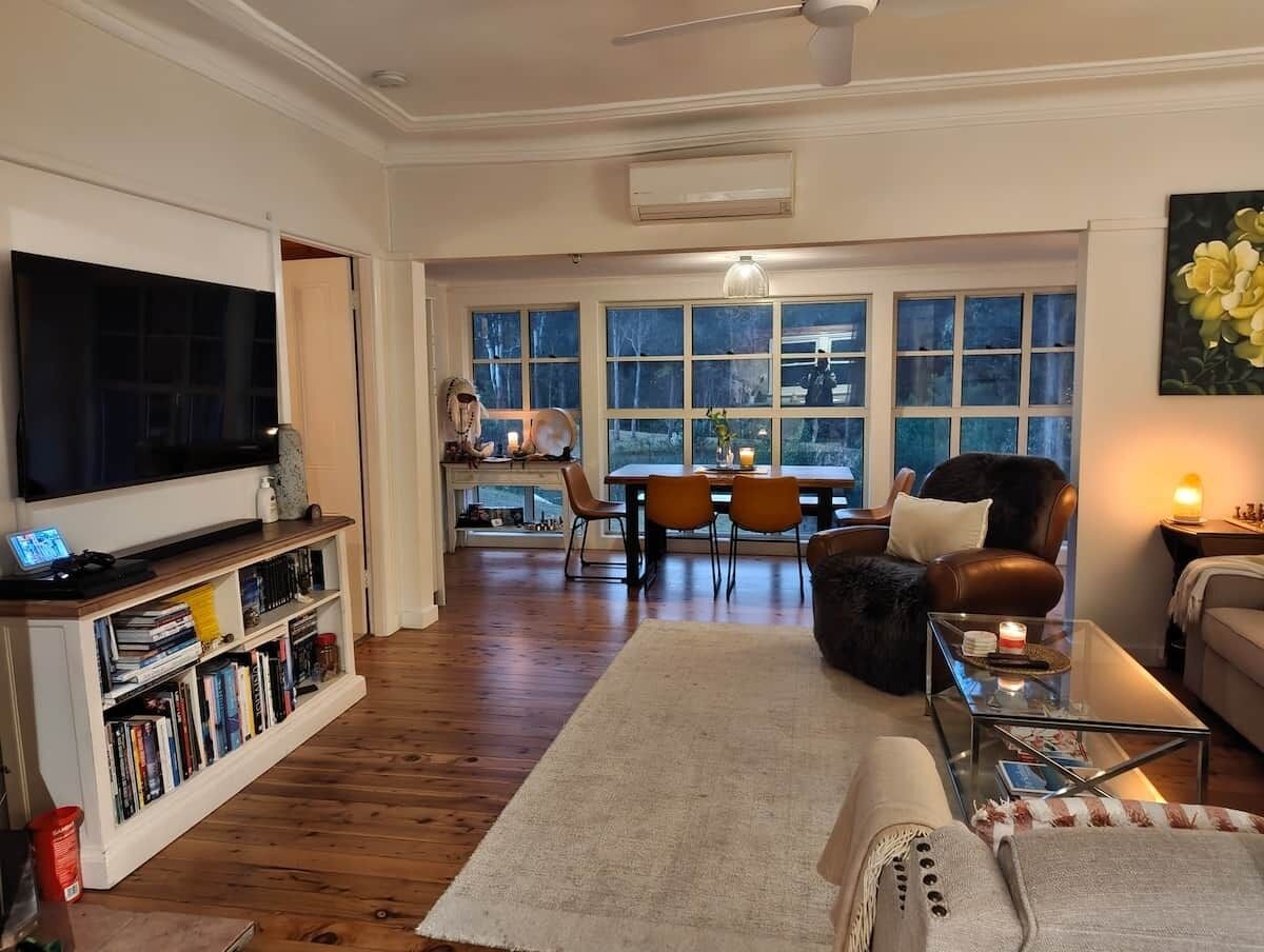 A living room with a flat-screen TV, bookshelves, a coffee table, and a sofa.
