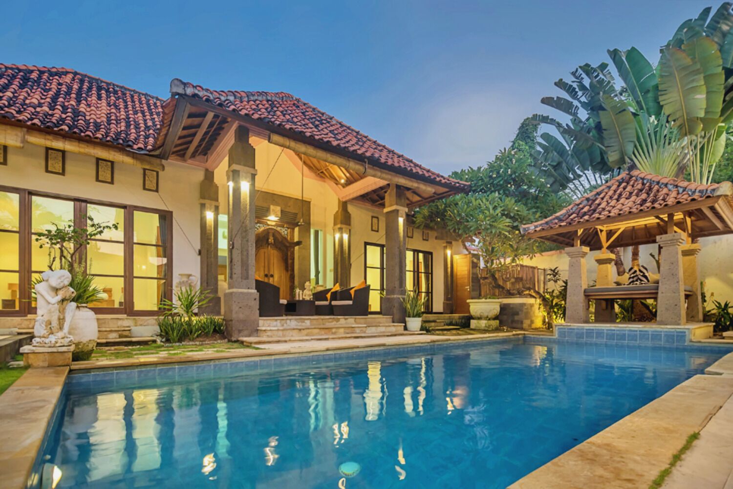 A house with a swimming pool, large windows, and a covered patio area.