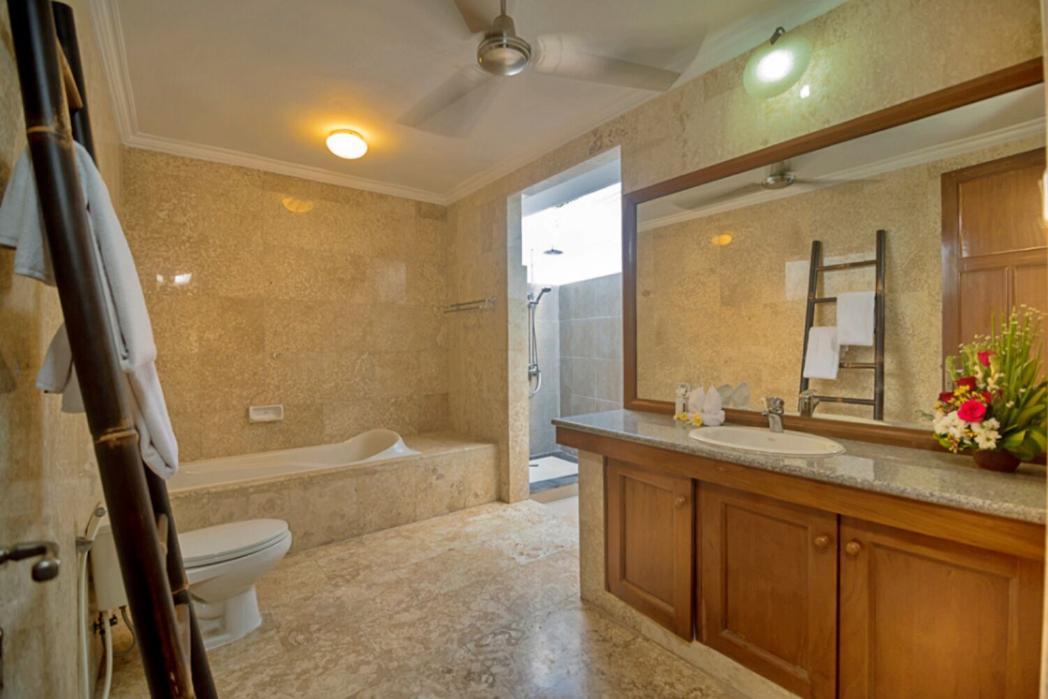 A bathroom with a bathtub, toilet, and a vanity with a mirror.