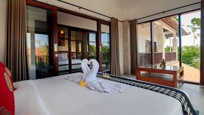Un dormitorio amplio con una cama grande, un balcón con vistas y una puerta corrediza que da a una zona de piscina.