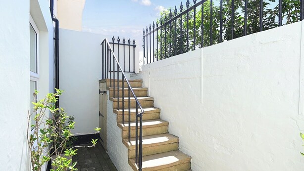 A concrete staircase with metal railings leading to a white wall. - 1 Bed - Sleeps 2 - Near Beach - Parking (Hastings)