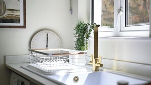 A modern kitchen with a sink, a scale, and a window with a view. - 1 Bed - Sleeps 2 - Near Beach - Parking (Hastings)