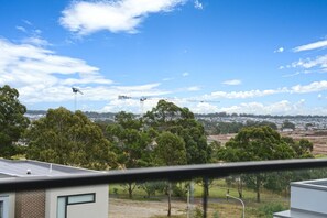 A residential area with multiple construction cranes, a clear sky, and a mix of trees and buildings. - Brand New Family Home for 10 | Boxhill (Box Hill)