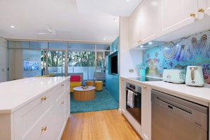 A modern kitchen with a dishwasher, a coffee maker, and a microwave. - The Fishbowl - 1Bed-1Bath-1Car-Pool (Bulimba)