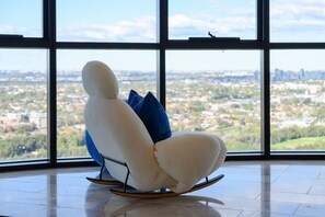 Ein moderner Schaukelstuhl mit Blick auf die Stadt durch große Fenster.