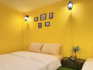 A room with a bed, a suitcase, and wall-mounted picture frames. - Night Market View Apartment, Inside Walking Street, Large Balcony, Max 5 (Hà Nội)