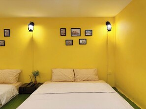 A room with two beds, each with checkered bedding, a small table with a vase and a remote control, and wall-mounted picture frames. - Night Market View Apartment, Inside Walking Street, Large Balcony, Max 5 (Hà Nội)