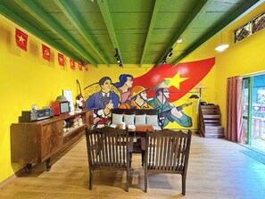 A room with a mural, wooden furniture, and a staircase. - Night Market View Apartment, Inside Walking Street, Large Balcony, Max 5 (Hà Nội)