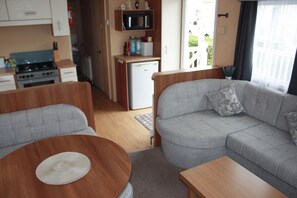 A compact living space with a kitchenette, a sofa, and a dining table. - 8 Berth caravan at Butlins Skegness Pets friendly (Skegness)