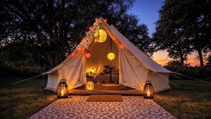 A tent set up on grass with a moon lantern and candles inside, surrounded by trees. - Countryside Avon Escape for Two (Pewsey)