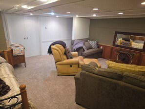 Ein Wohnzimmer mit Sofa, Sessel und einem kleinen Tisch mit dekorativer Tischdecke.