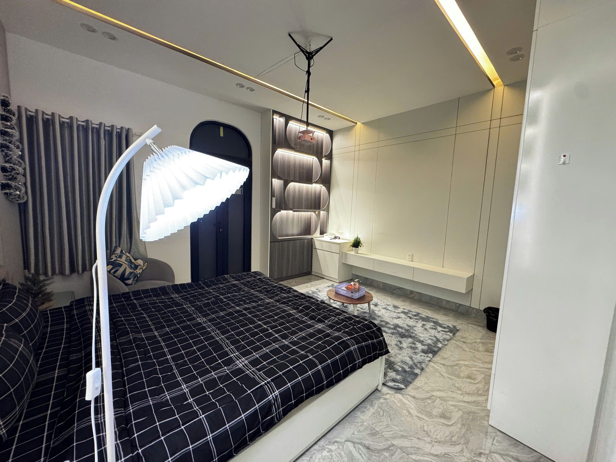 Ein modernes Schlafzimmer mit Bett, Nachttisch, Lampe und Einbauschrank.