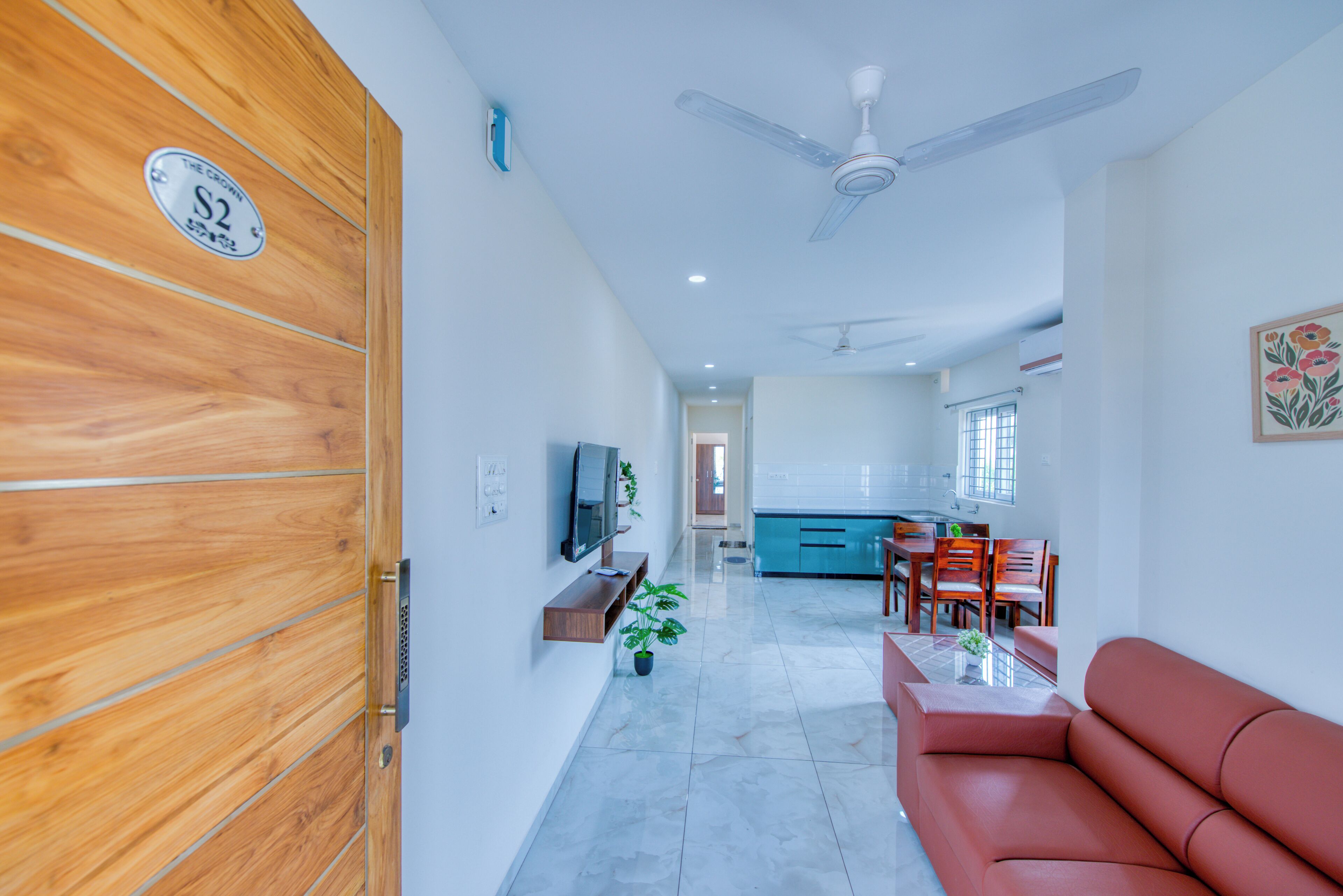 Una sala moderna con un sofá, un televisor y un ventilador de techo.
