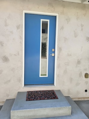 A blue door with a white frame, a small window, and a doormat with the word 'WELCOME'. - Tranquil 1-bedroom studio with AC in charming Chula Vista (Chula Vista)