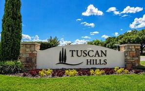 A sign for Tuscan Hills with a landscaped garden in front. - 5BR Disney Home, Private Pool, Spa & PS5 Game Loft (Davenport)