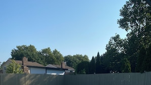 A swimming pool with a wooden fence and a clear blue sky in the background. - Cozy 2-bedroom house in fantastic Windsor with AC (Windsor)