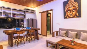 Uma sala de estar moderna com uma mesa de jantar de madeira, um sofá e uma pintura de Buda.