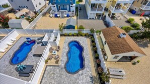 Ett bostadsområde med två pooler, en täckt uteplats och en byggnad i två våningar.
