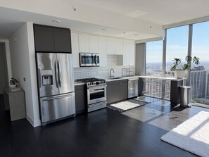 Eine moderne Küche mit Edelstahlgeräten, einem großen Fenster und Blick auf die Stadt.