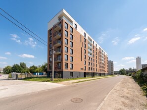 A multi-story residential building with a modern design, featuring balconies and large windows. - Portowa Riverside Apartment (Kraków)