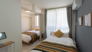 Une chambre d’hôtel avec un lit, une table de chevet et une fenêtre avec des rideaux.