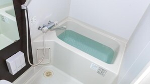 Une salle de bain avec une baignoire, une douche et des toilettes.