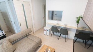 Un salon moderne comprenant un canapé, une table basse et un coin repas avec des chaises et une table.