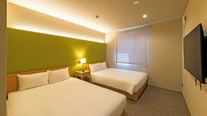 A hotel room with two beds, a nightstand with a lamp, a television, and a window with blinds.
