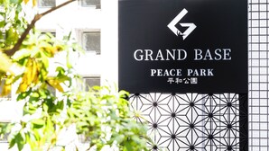 A sign for 'GRAND BASE PEACE PARK' with a geometric pattern and a logo.