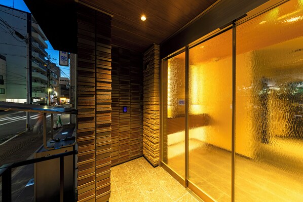 Une façade moderne avec une entrée en verre et un escalier en métal.
