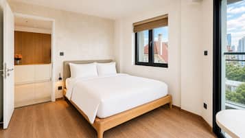 Un dormitorio con cama, ventana con vistas y puerta que da a un baño.