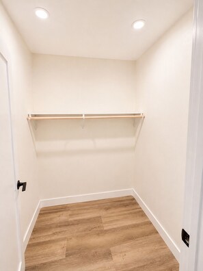 Une pièce dotée d’un plancher en bois, de murs blancs et d’un plafond pourvu d’un éclairage encastré.