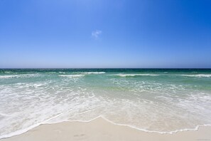 Ein Strand mit klarem, blauem Wasser und einem sandigen Ufer.