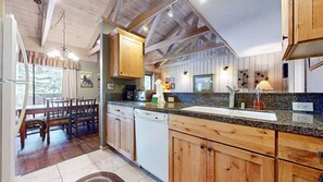 A rustic kitchen with wooden cabinets, a granite countertop, and a dishwasher. - Seasons 4 #104 2 Bedroom Condo (Mammoth Lakes)