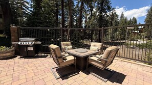 An outdoor patio with a grill, four chairs, and a table. - Seasons 4 #104 2 Bedroom Condo (Mammoth Lakes)