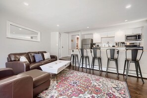 A modern living room with a brown leather sofa, a white coffee table, and a patterned rug. - Gold Camp F97 2 Bedroom Condo (Breckenridge)