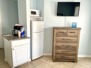 A kitchen with a white refrigerator, a microwave, a coffee maker, and a wooden cabinet with drawers. - Beachgate Condo Suites And Hotel 537a+537b 2 Bedroom Condo (Port Aransas)