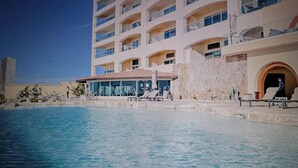 A hotel with a swimming pool, multiple balconies, and a clear sky. - Ross Rosarito (Playas de Rosarito)