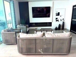 A modern living room with a large sofa, a coffee table, and a flat-screen TV mounted on the wall. - Ross Rosarito (Playas de Rosarito)