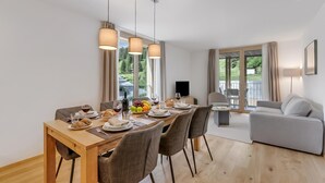 Un espace repas comprenant une table en bois, des chaises et des lampes suspendues.