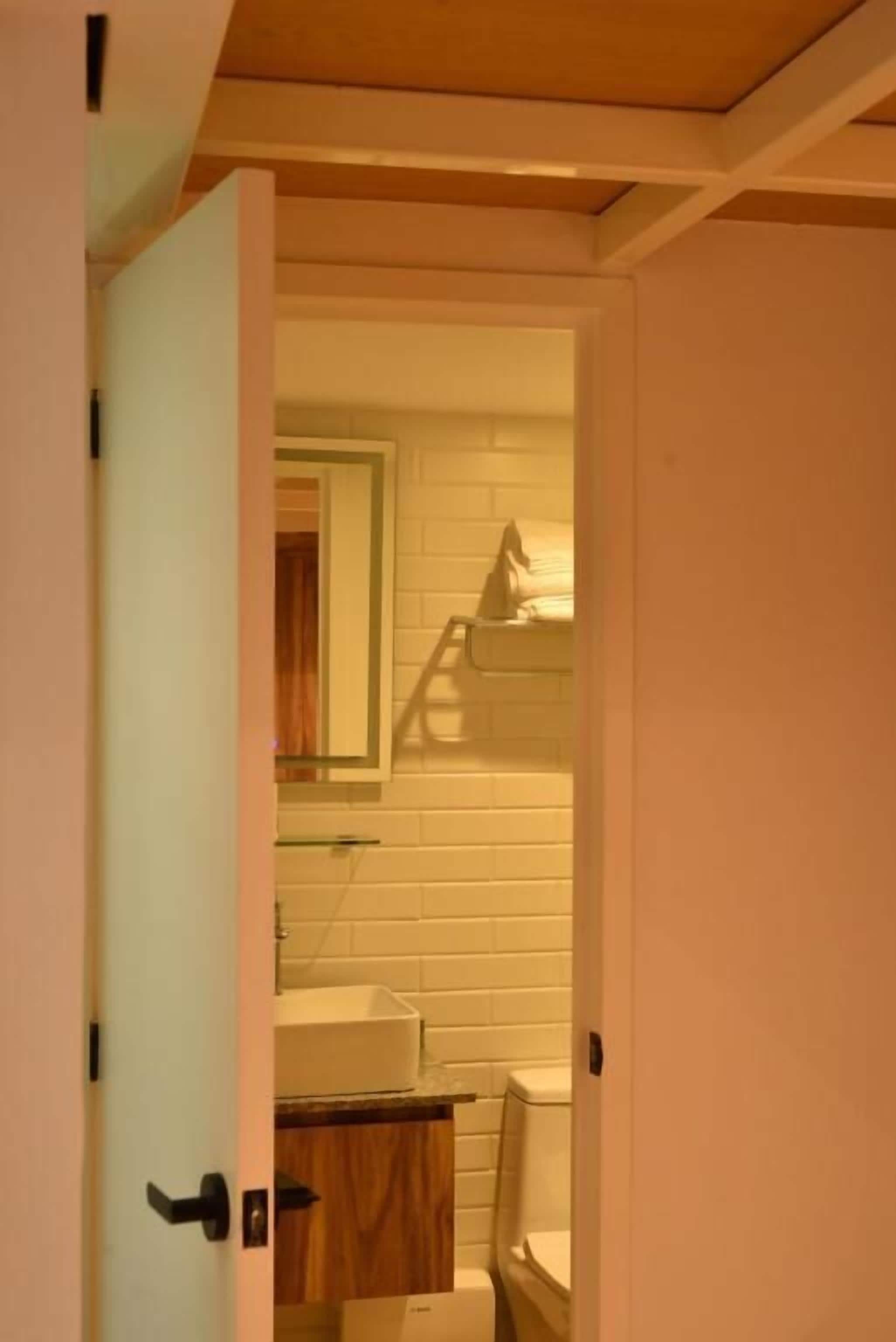 A bathroom with a toilet, sink, and mirror.