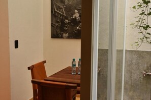 A room with a wooden table, two chairs, and a water bottle on the table. - Lopez Cotilla 658 (Guadalajara)