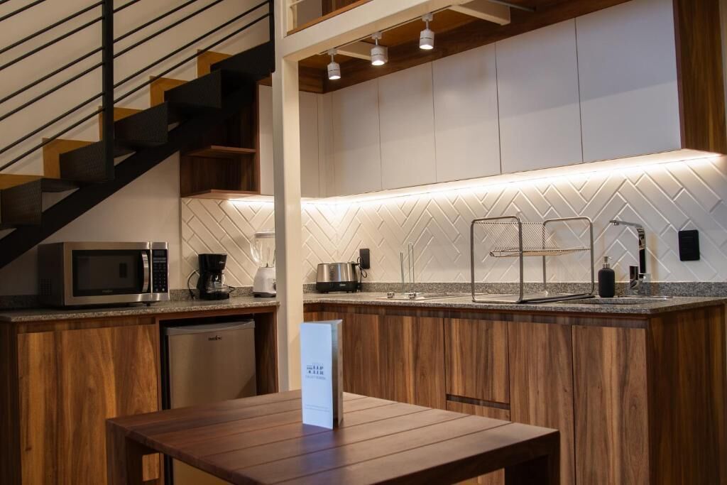 Una cocina moderna con salpicadero de baldosas tipo espiga, electrodomésticos de acero inoxidable y una mesa de comedor de madera.