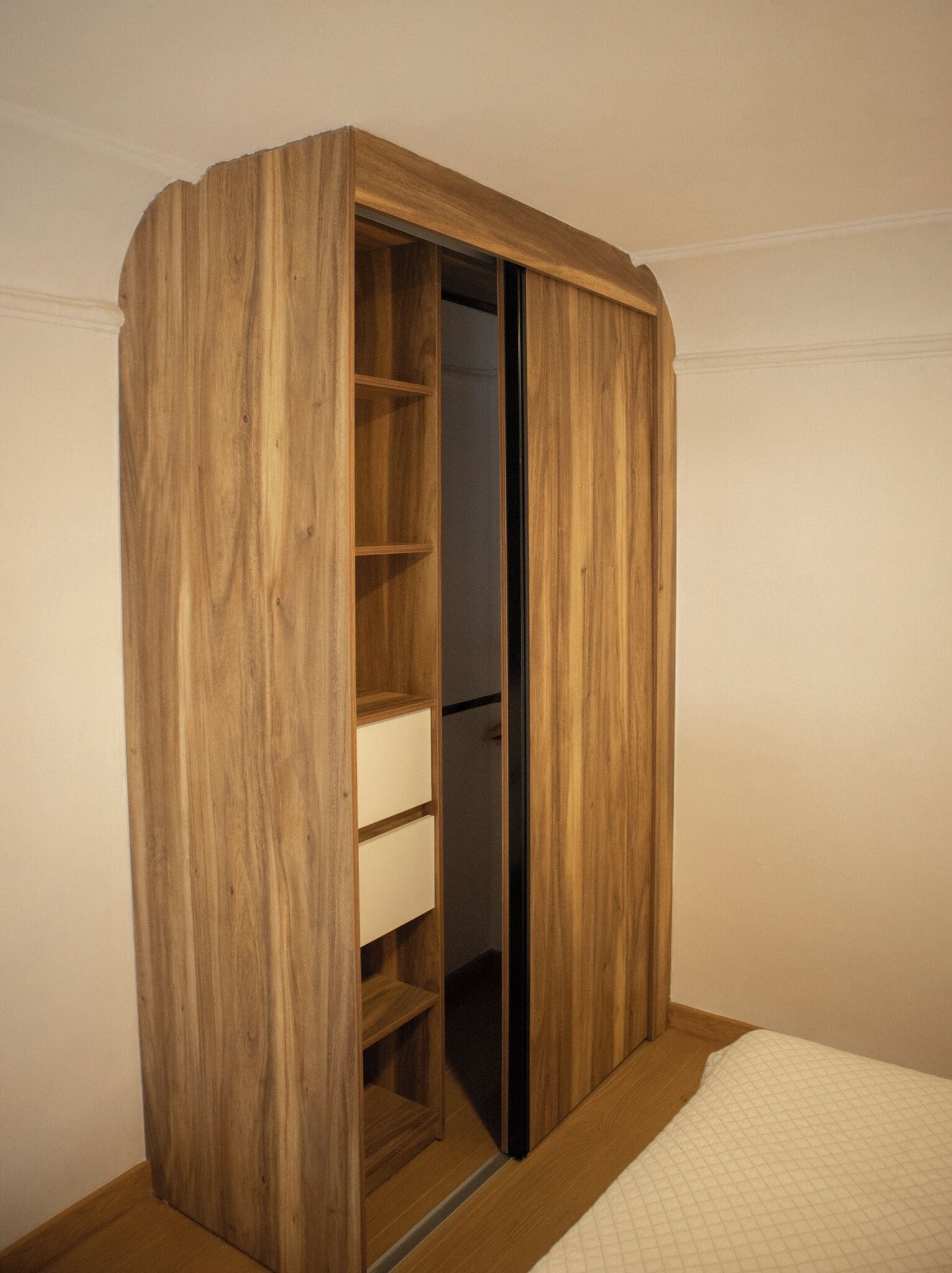 Un armario de madera con puerta corredera, varios estantes y un compartimento inferior.