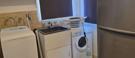 Cocina compacta con lavadora, secadora y refrigerador.